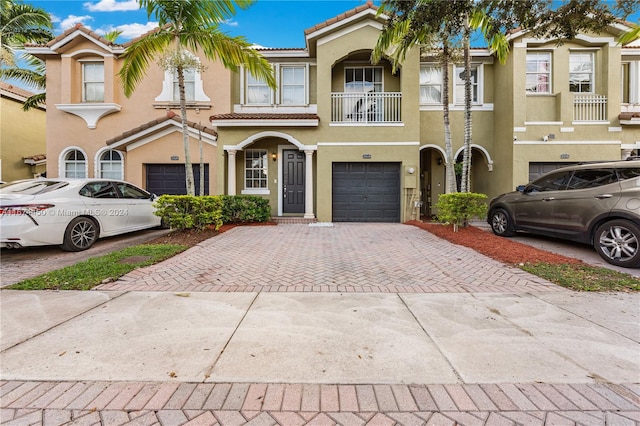 townhome / multi-family property with a balcony and a garage