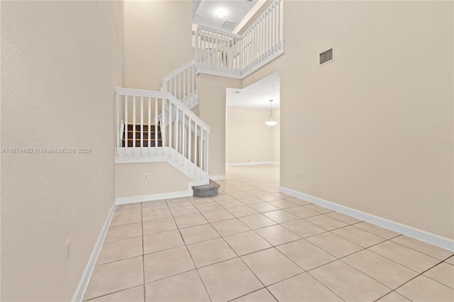 stairs with a high ceiling and tile patterned floors