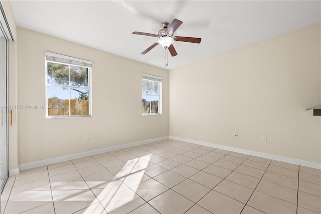 tiled empty room featuring a wealth of natural light and ceiling fan