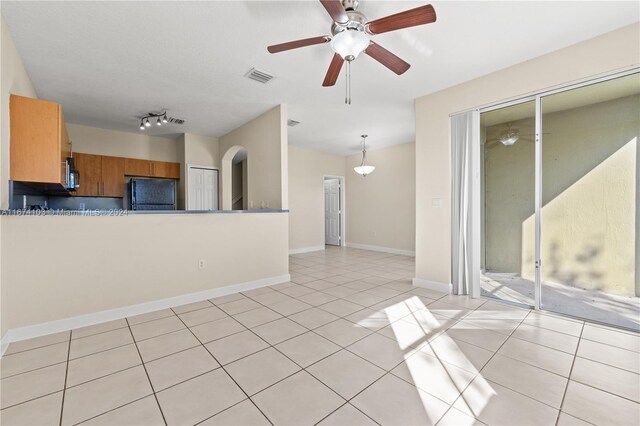 unfurnished living room featuring light tile patterned floors and ceiling fan