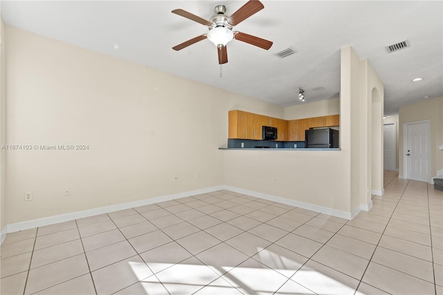 kitchen featuring light brown cabinetry, black appliances, ceiling fan, and light tile patterned floors