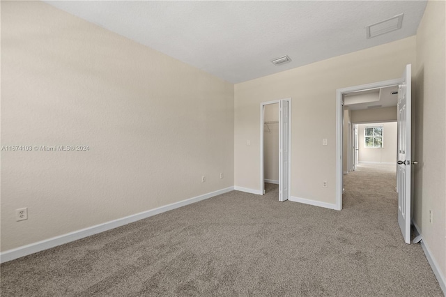 unfurnished bedroom featuring light colored carpet and a closet