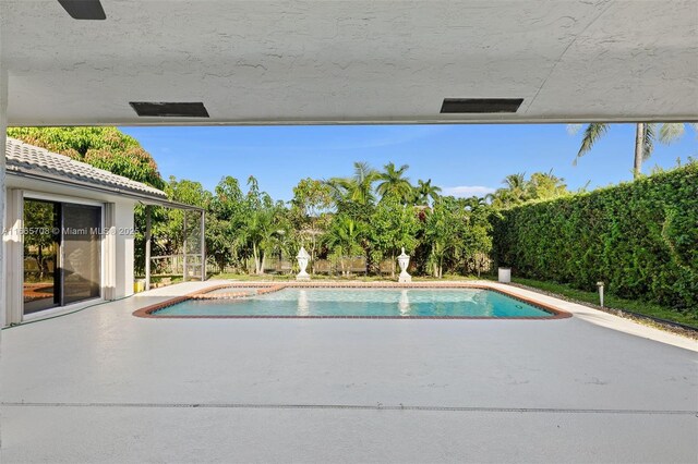 view of pool with ceiling fan and a patio