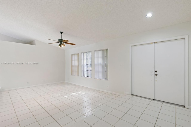 tiled empty room featuring ceiling fan, a textured ceiling, and vaulted ceiling