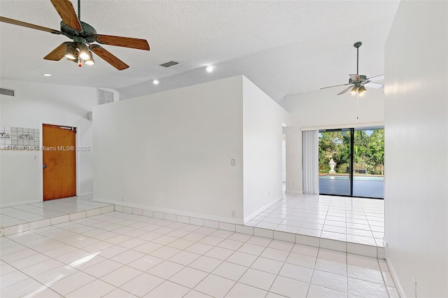 tiled empty room with ceiling fan, lofted ceiling, and a textured ceiling