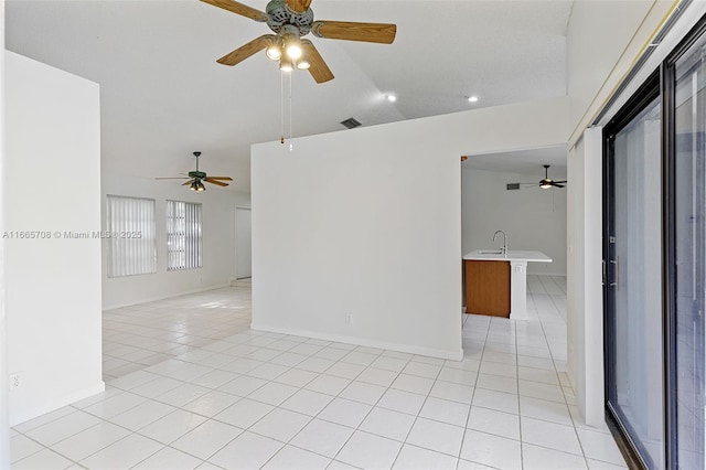 empty room with light tile patterned flooring, sink, and vaulted ceiling