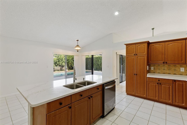 kitchen featuring lofted ceiling, a kitchen island with sink, sink, stainless steel dishwasher, and decorative backsplash