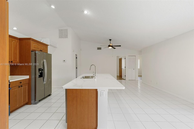 kitchen featuring ceiling fan, a kitchen island with sink, sink, stainless steel fridge with ice dispenser, and lofted ceiling