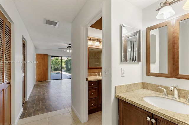 bathroom featuring tile patterned floors, vanity, ceiling fan, and a textured ceiling