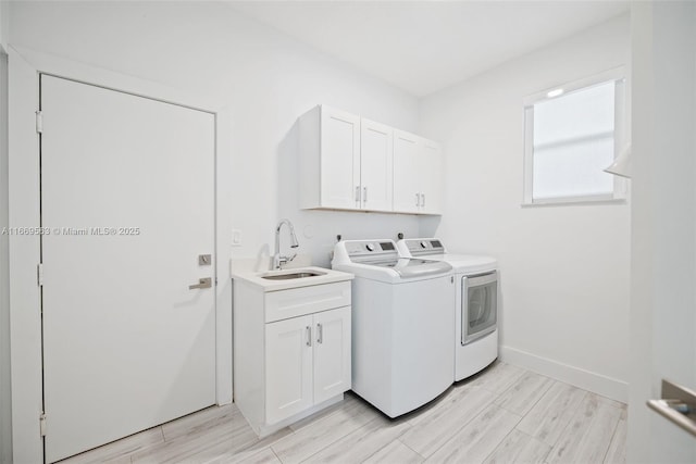 washroom featuring light hardwood / wood-style floors, cabinets, separate washer and dryer, and sink