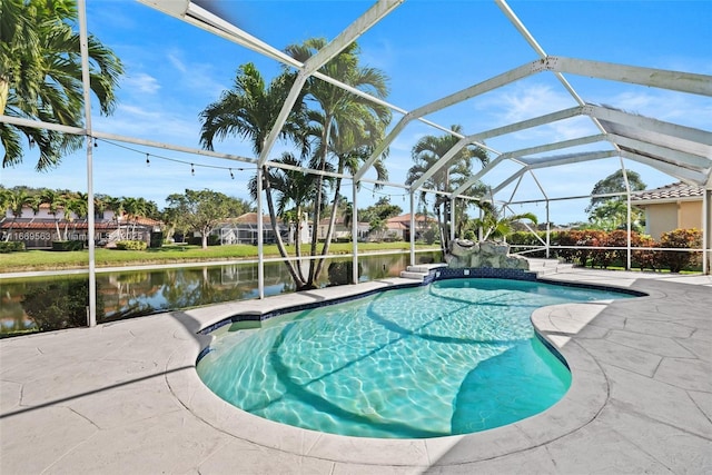 view of pool featuring glass enclosure, a patio area, and a water view