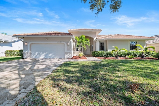 mediterranean / spanish home with a garage and a front lawn