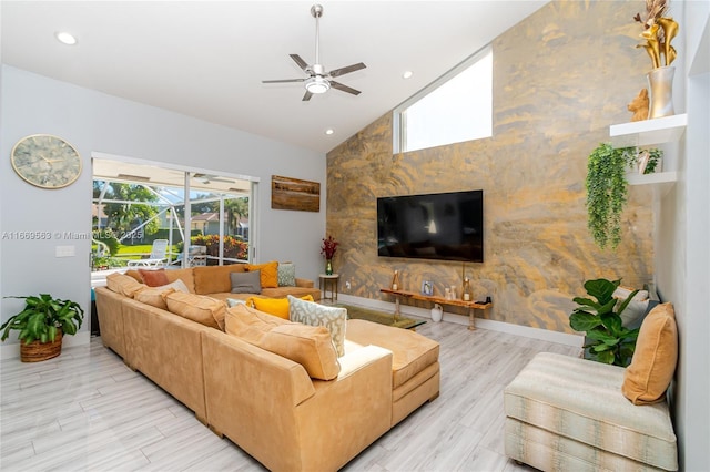 living room with ceiling fan, high vaulted ceiling, and light wood-type flooring