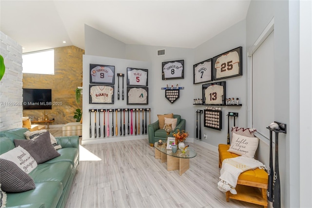 living area with light hardwood / wood-style flooring and vaulted ceiling