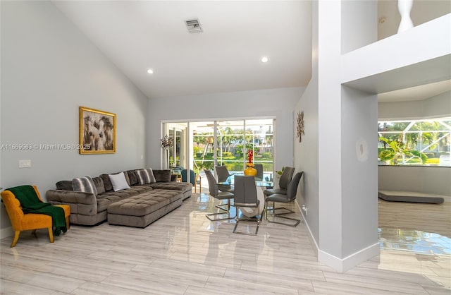 living room with high vaulted ceiling and a healthy amount of sunlight