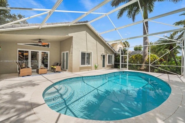 view of swimming pool featuring a lanai, a patio area, ceiling fan, and french doors