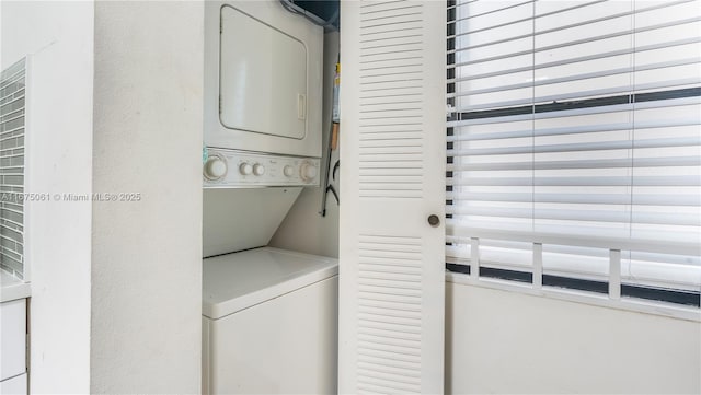 washroom featuring stacked washer / dryer