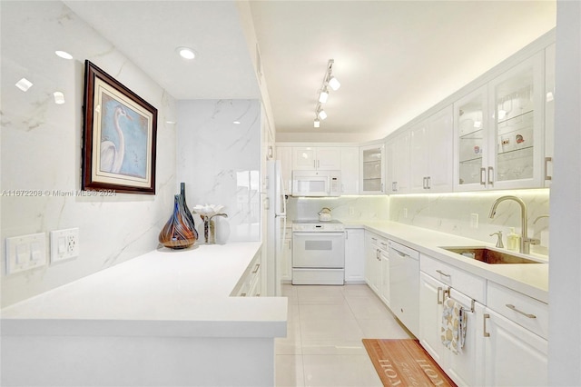 kitchen with decorative backsplash, white appliances, sink, white cabinetry, and light tile patterned floors