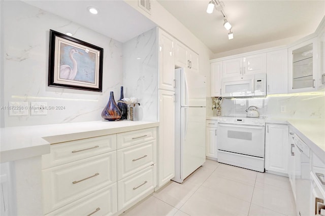 kitchen with decorative backsplash, white appliances, and white cabinets