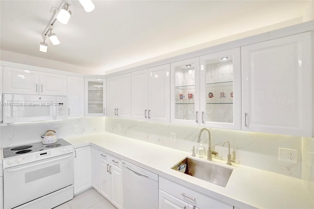 kitchen featuring rail lighting, white appliances, sink, light tile patterned flooring, and white cabinetry