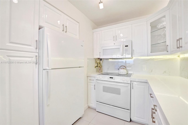 kitchen featuring white appliances, light tile patterned floors, and white cabinets