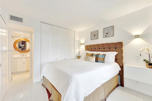 tiled bedroom with sink, ensuite bath, and a closet