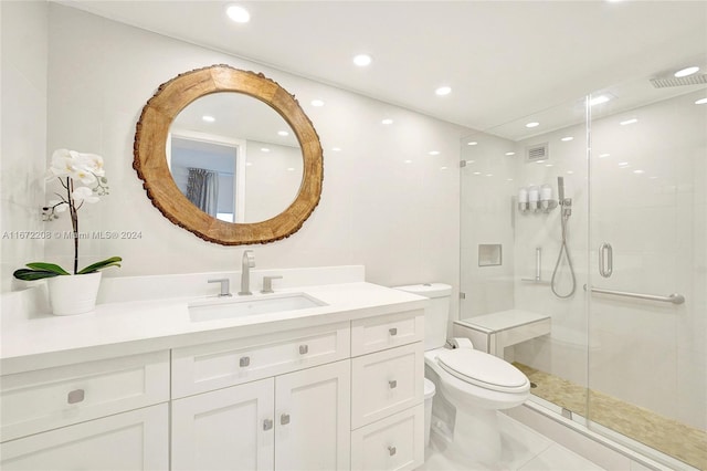 bathroom with vanity, toilet, and a shower with door