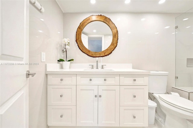 bathroom with tile walls, vanity, and toilet