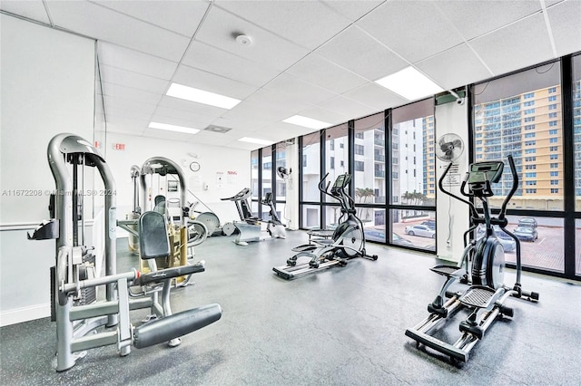 workout area featuring a drop ceiling, floor to ceiling windows, and a wealth of natural light