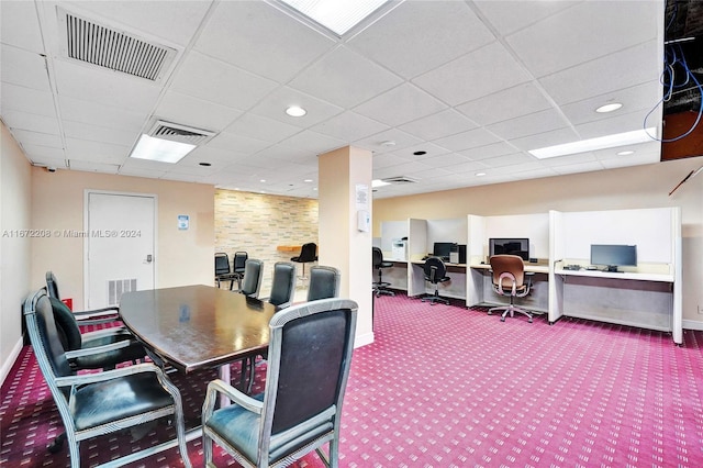 carpeted dining room featuring a drop ceiling and built in desk