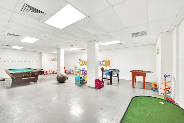 game room with a paneled ceiling and concrete flooring