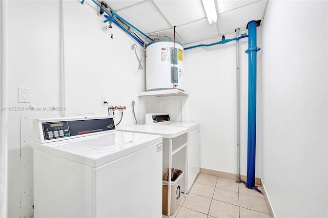 laundry area with light tile patterned flooring, separate washer and dryer, and electric water heater