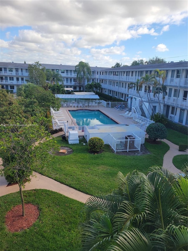 view of swimming pool featuring a yard