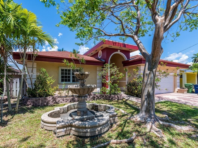 232 SW 7th Ave, Hallandale Beach, FL 33009 - view of front of home with stucco siding, an attached garage, and driveway