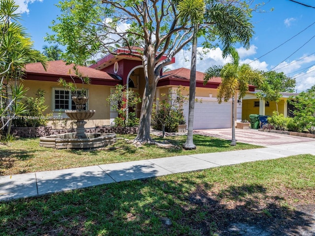 232 SW 7th Ave, Hallandale Beach, FL 33009 - view of front of property featuring stucco siding, an attached garage, a front yard, and driveway