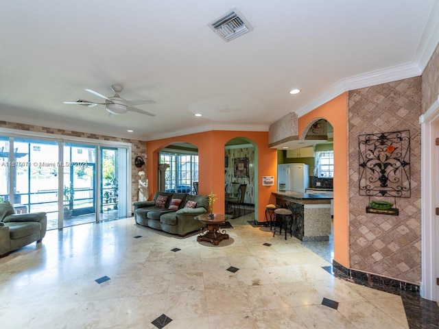 living room with ceiling fan and ornamental molding