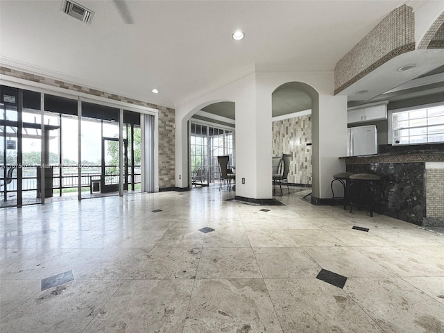 232 SW 7th Ave, Hallandale Beach, FL 33009 - living area with arched walkways, stone tile flooring, crown molding, baseboards, and recessed lighting