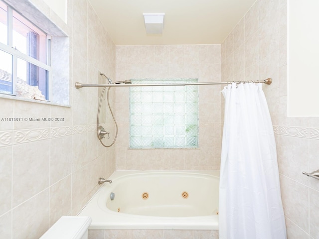 bathroom featuring shower / bath combination with curtain and tile walls