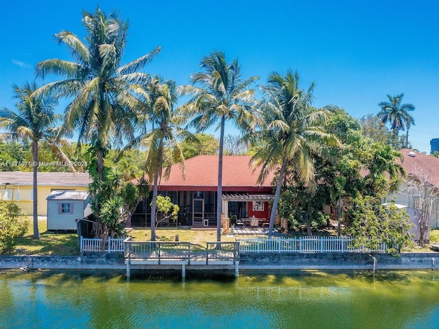 rear view of property with a water view and a yard