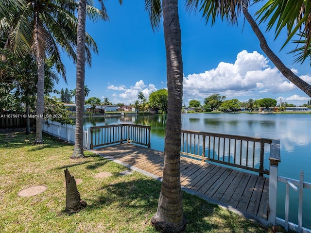 view of dock with a lawn and a deck with water view