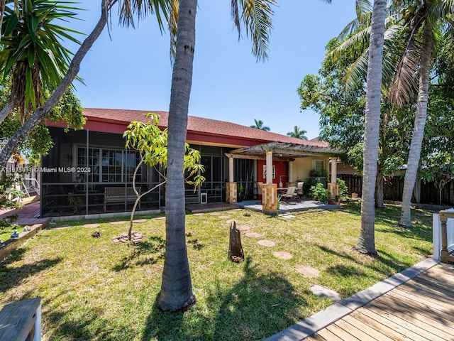 exterior space featuring a front yard, a sunroom, and a patio