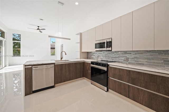 kitchen with dark brown cabinetry, ceiling fan, stainless steel appliances, tasteful backsplash, and sink