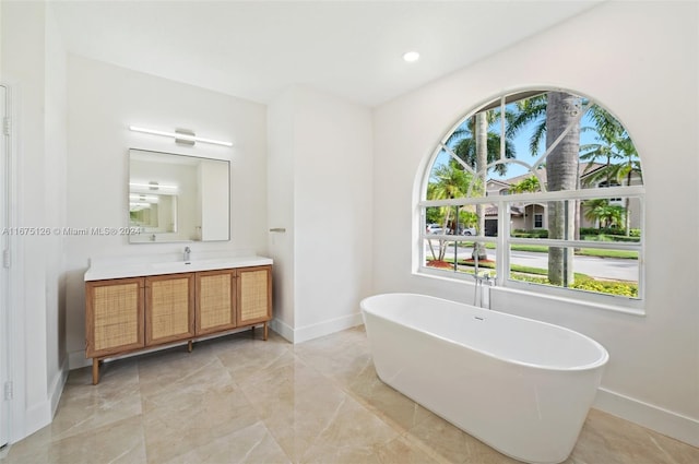 bathroom with a washtub and vanity