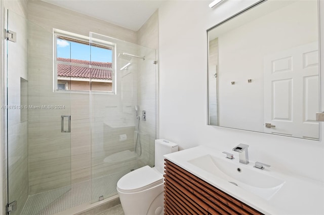 bathroom featuring vanity, a shower with door, and toilet