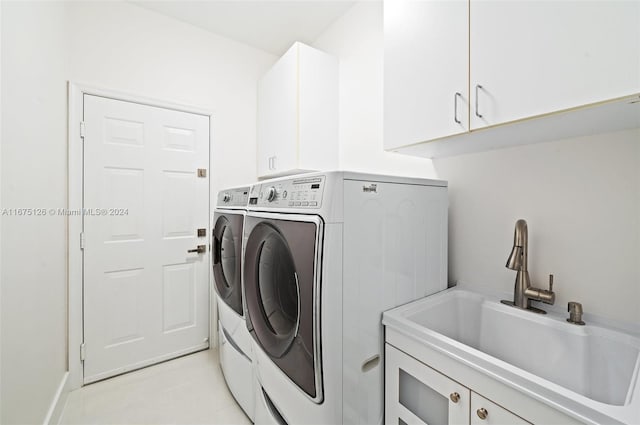 laundry room with washer and clothes dryer, sink, light tile patterned floors, and cabinets