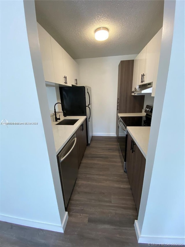 kitchen with stainless steel appliances, white cabinets, and dark wood-type flooring