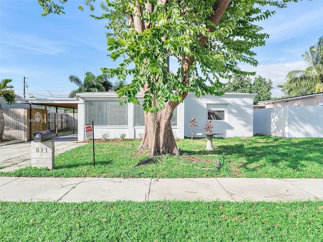 view of front of home with a front yard and a carport