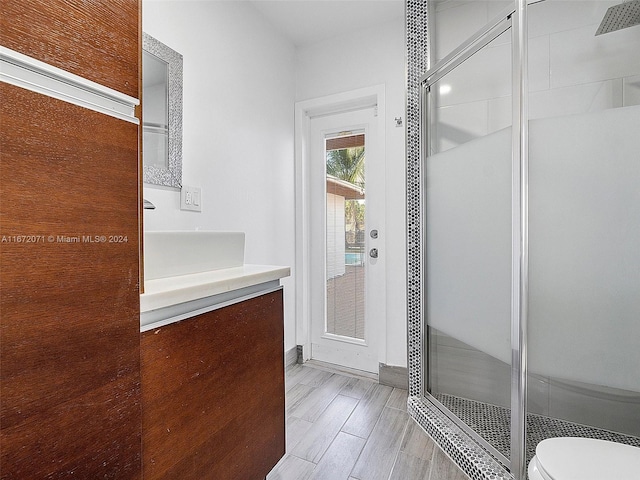 bathroom featuring vanity, an enclosed shower, hardwood / wood-style flooring, and toilet