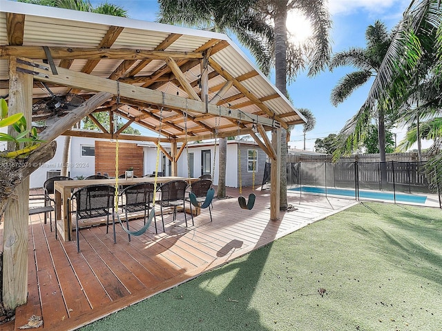 deck featuring a gazebo, a lawn, and a fenced in pool