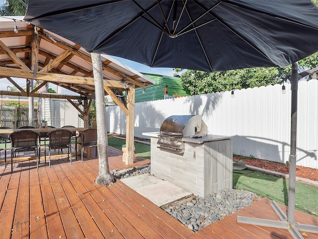 deck with a grill and an outdoor kitchen